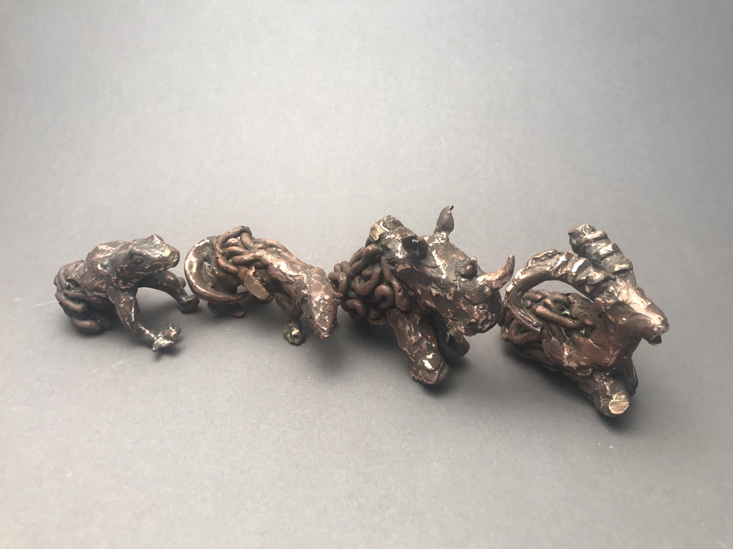 Four metal sculptures of extinct animals